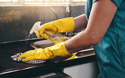 Buy stock photo Cropped shot of an unrecognizable woman using cleaning detergent to clean her kitchen at home