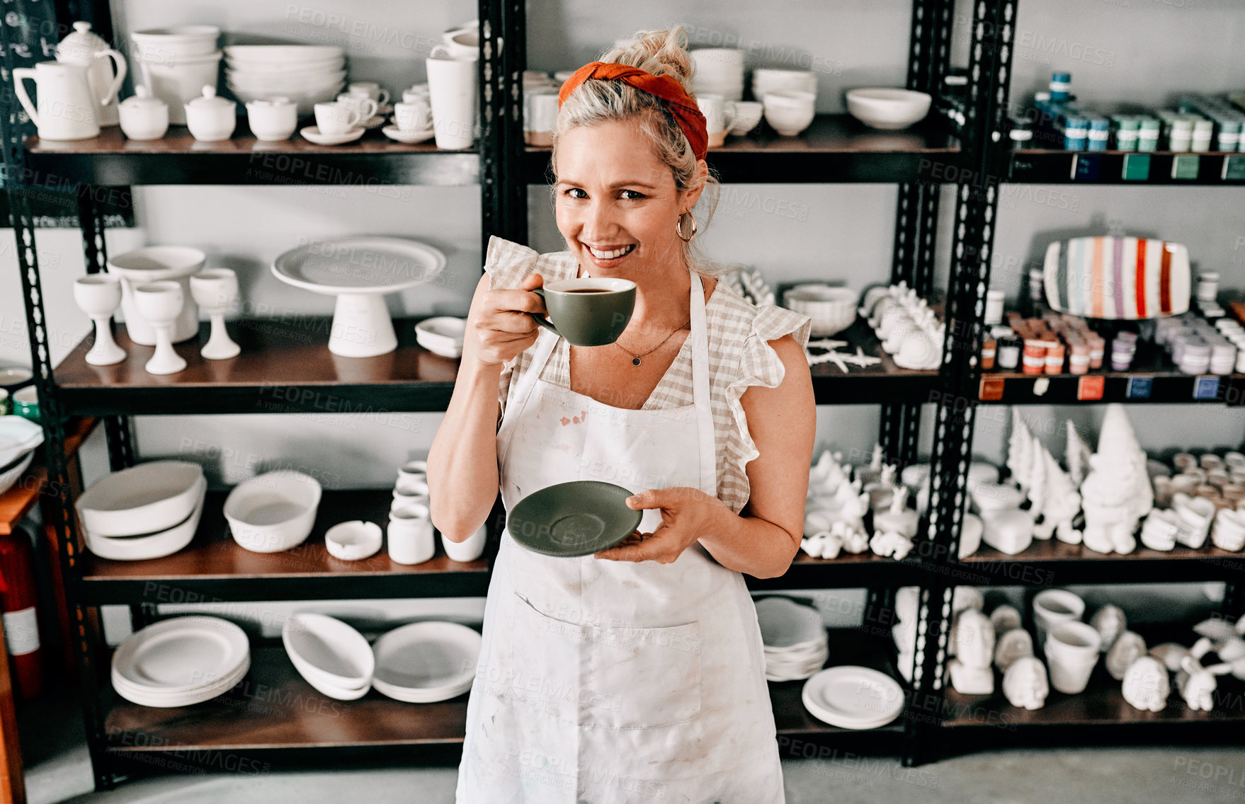 Buy stock photo Cropped portrait of an attractive mature woman standing alone and holding a cup of coffee in her pottery workshop