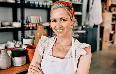 Buy stock photo Cropped portrait of an attractive mature woman sitting with her arms folded in her pottery workshop