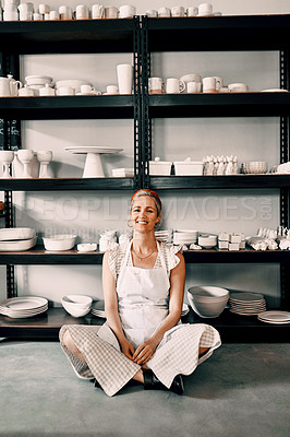 Buy stock photo Full length portrait of an attractive mature woman sitting contently on the floor alone in her pottery workshop