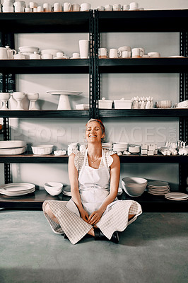 Buy stock photo Full length shot of an attractive mature woman sitting contently on the floor alone in her pottery workshop
