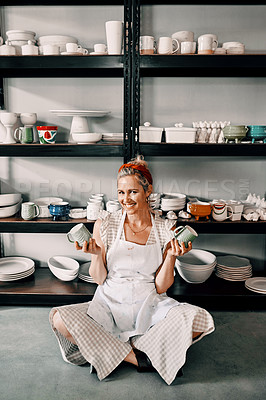 Buy stock photo Full length portrait of an attractive mature woman sitting on the floor and holding her pottery in her workshop