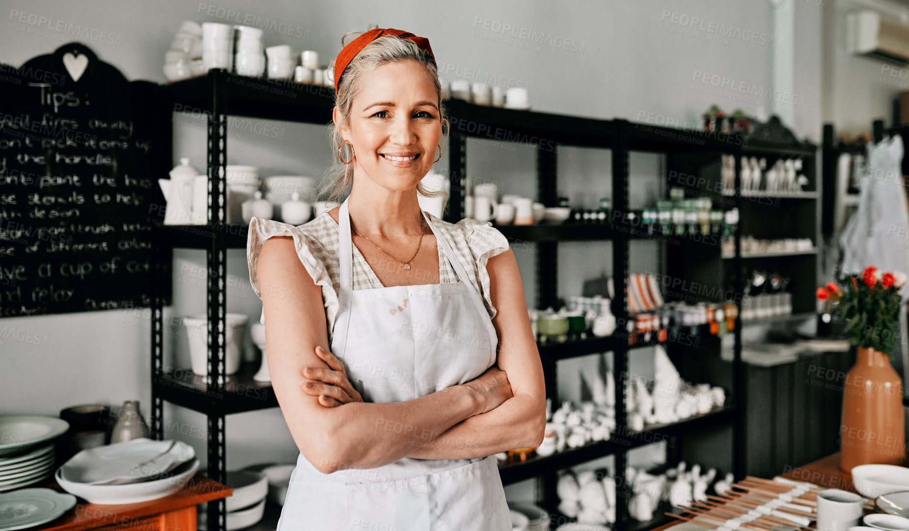 Buy stock photo Cropped portrait of an attractive mature woman standing with her arms folded in her pottery workshop