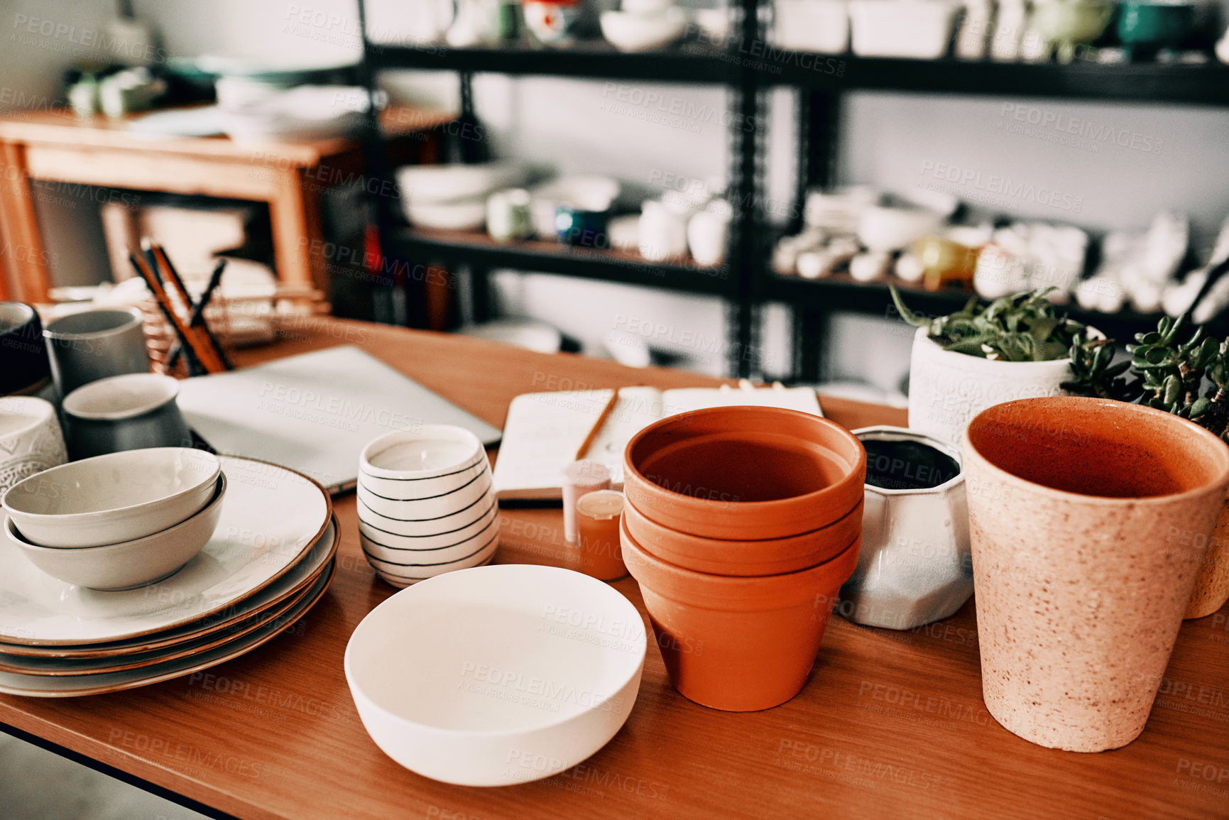 Buy stock photo High angle shot of a potter's collection and a notebook in her workshop during the day