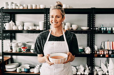 Buy stock photo Cropped portrait of an attractive mature woman standing alone and holding her finished pottery in her workshop