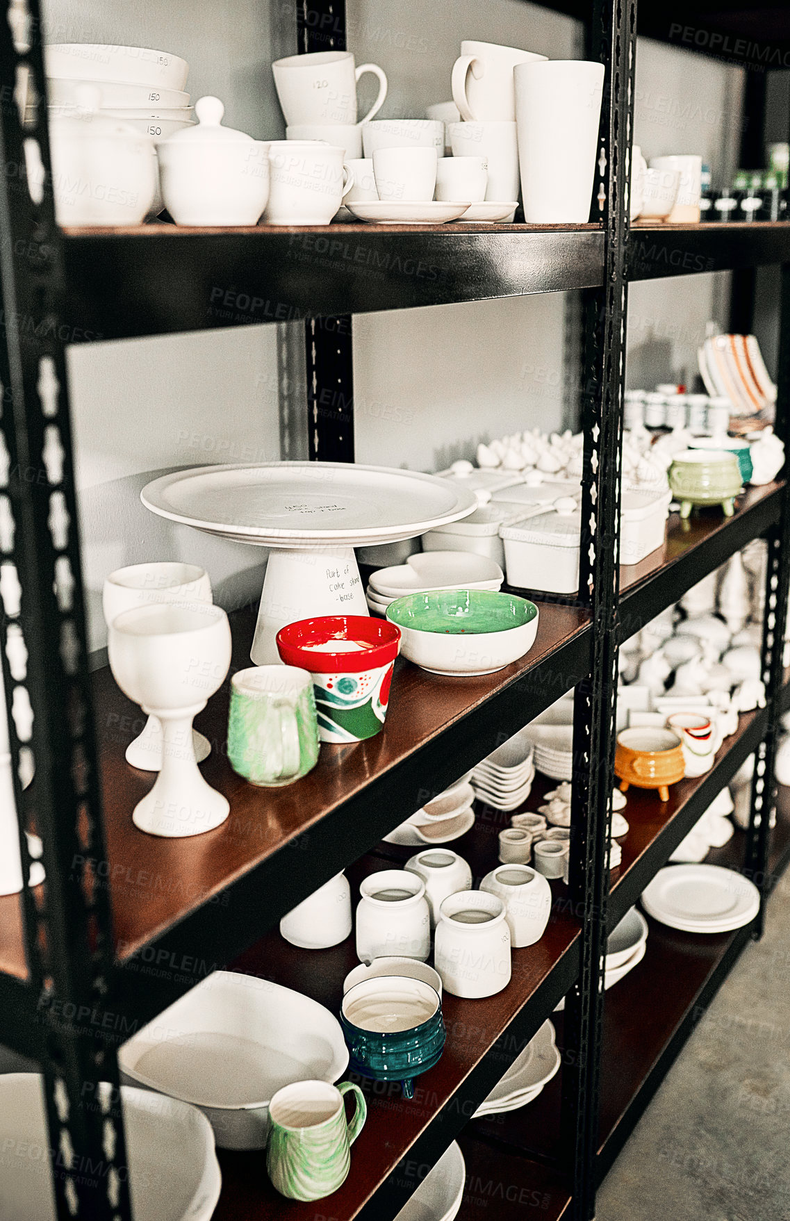 Buy stock photo Cropped shot of a potter's ceramic collection neatly arranged on a shelf in her studio