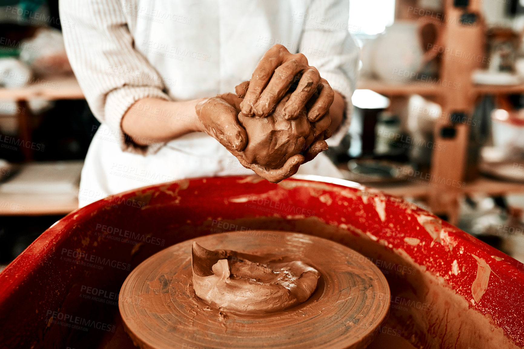 Buy stock photo Cropped shot of an unrecognizable woman molding clay on a pottery wheel