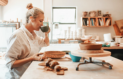 Buy stock photo Shot of a female artisan having coffee while working in her pottery workshop