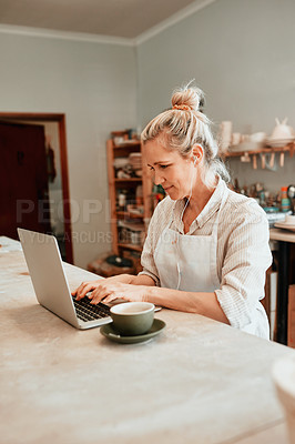 Buy stock photo Cropped shot of a artisan using a laptop in her workshop