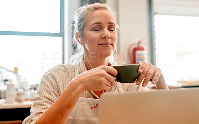 Buy stock photo Pottery, coffee and woman on laptop in workshop with earphones listening to artisan podcast for break. Calm, cappuccino and female potter with computer and audio tech for music in creative studio.