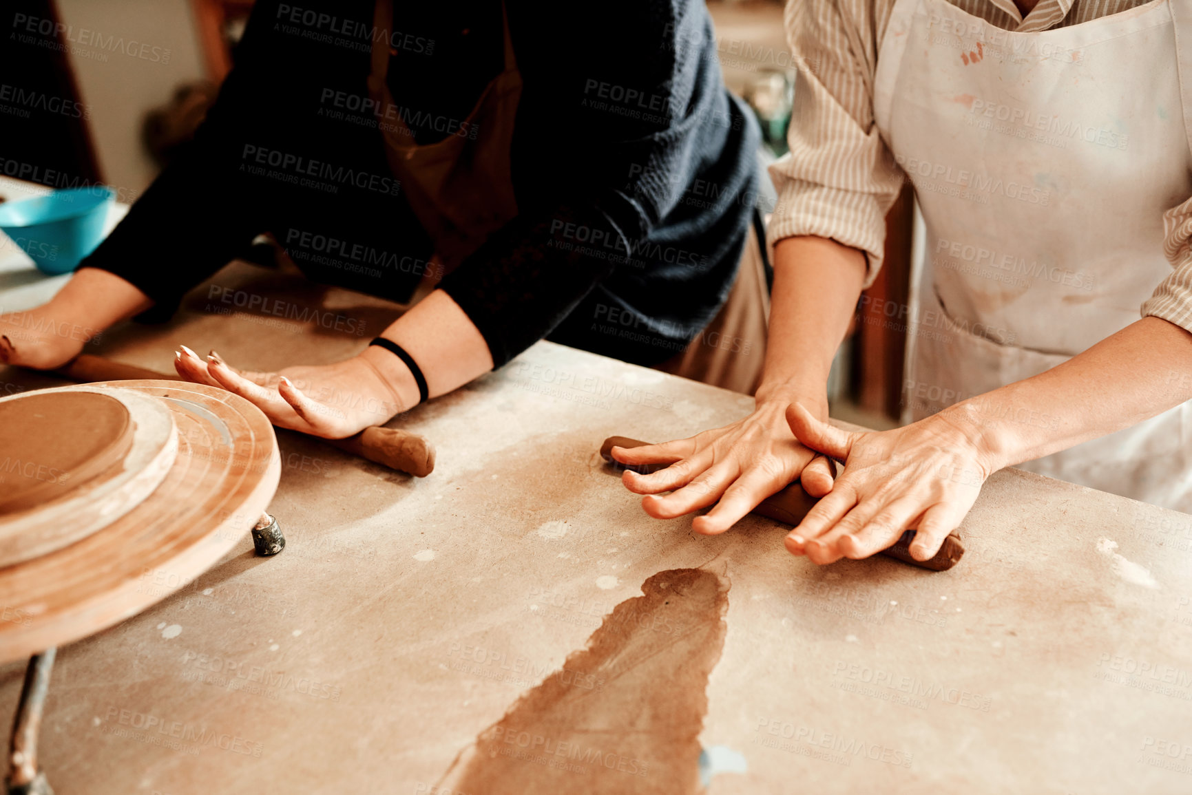 Buy stock photo Cropped shot of two artisans working together in a pottery workshop