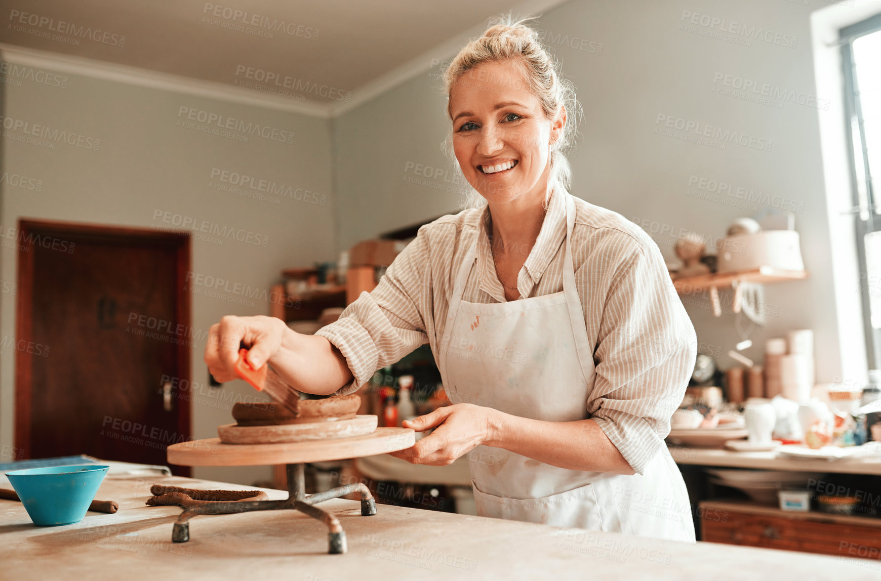 Buy stock photo Woman, clay and pottery wheel in portrait for craft, tools or sustainable production at small business. Person, artist and entrepreneur for eco friendly material, sculpture or manufacturing in studio