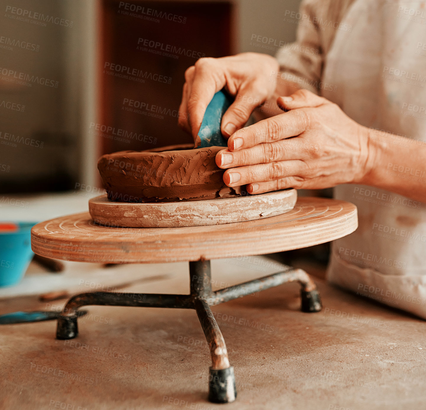 Buy stock photo Cropped shot of an unrecognizable woman shaping a clay pot in her workshop