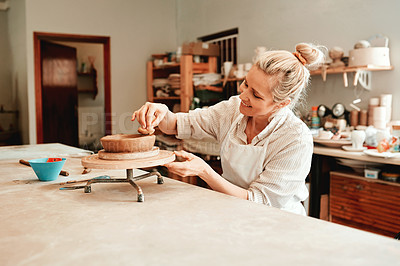 Buy stock photo Cropped shot of a woman shaping a clay pot in her workshop