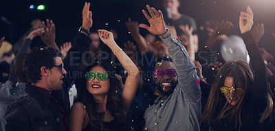 Buy stock photo Cropped shot of a group of young friends dancing together in a nightclub