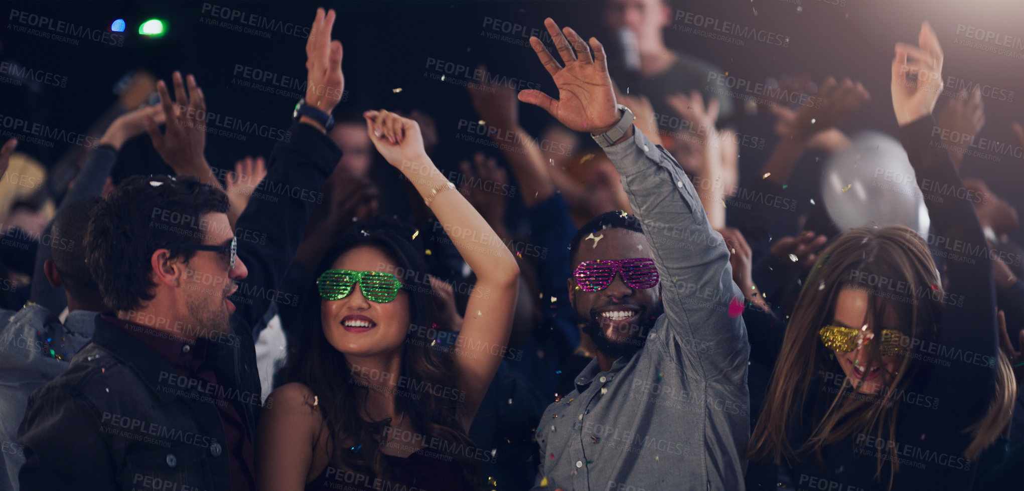 Buy stock photo Cropped shot of a group of young friends dancing together in a nightclub