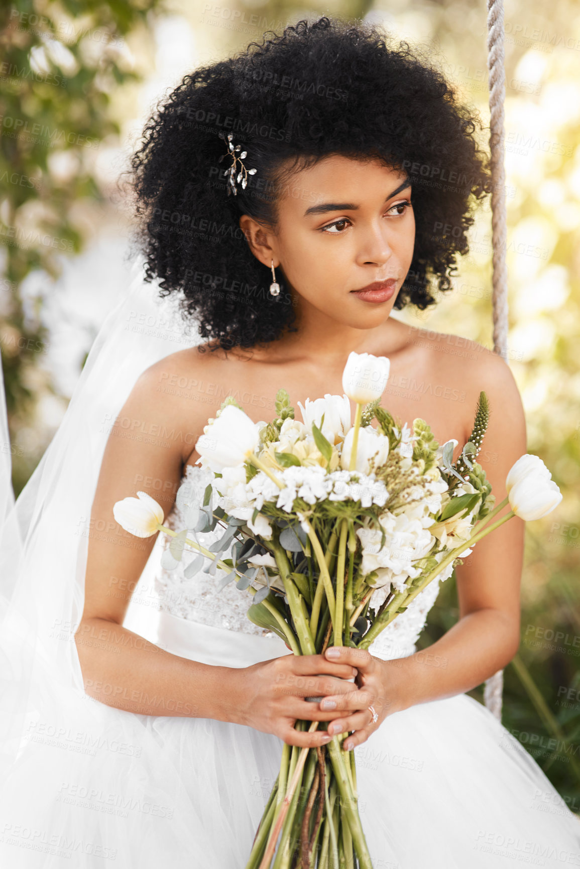 Buy stock photo Shot of a happy and beautiful young bride holding a bouquet of flowers while posing outdoors on her wedding day