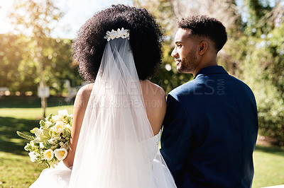 Buy stock photo Rearview shot of a newlywed young couple standing together outdoors on their wedding day