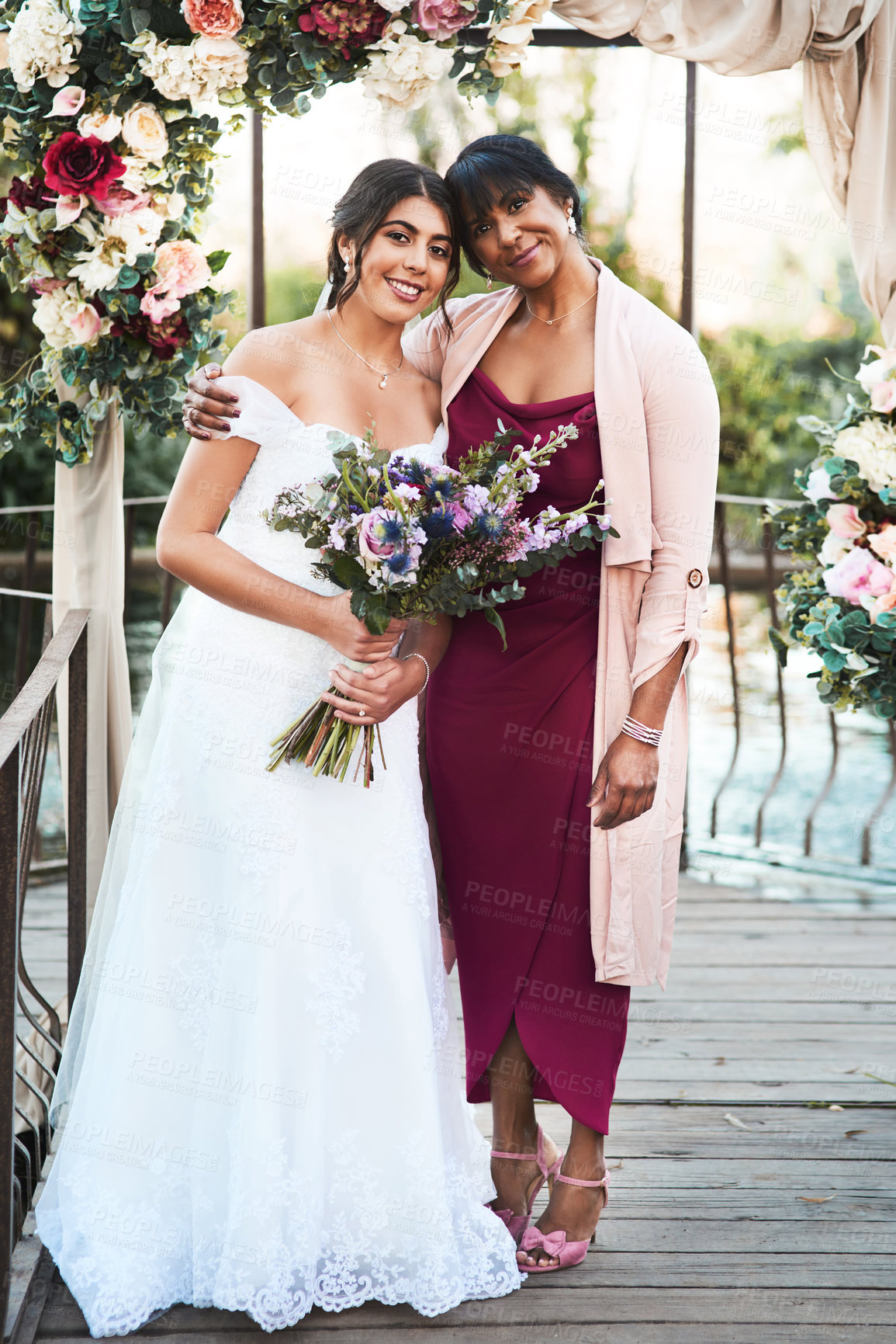 Buy stock photo Full length shot of a happy young bride posing with her mother outdoors on her wedding day