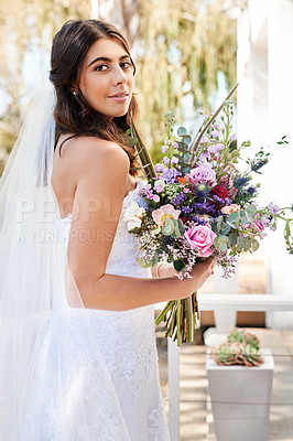 Buy stock photo Portrait of a happy and beautiful young bride holding a bouquet of flowers while posing outdoors on her wedding day