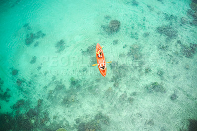 Buy stock photo High angle shot of an adventurous young couple canoeing together in the beautiful oceans of Indonesia