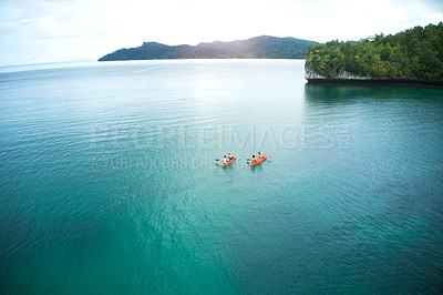 Buy stock photo High angle shot of two adventurous young couples canoeing together in the beautiful oceans of Indonesia