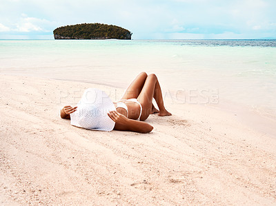 Beautiful happy girl smiling and streching her tight blue swimming suit  while having a sunbath. Relaxing on an island Stock Photo