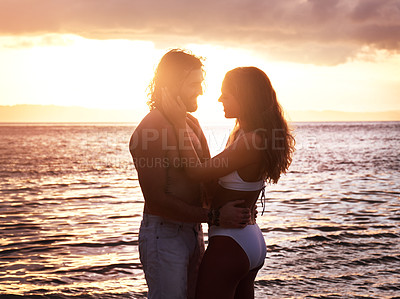 Buy stock photo Happy couple, hug and sunset at the beach for love, quality time or bonding together in the water. Man and woman hugging in loving romance, sunrise or sunshine in the ocean for romantic holiday