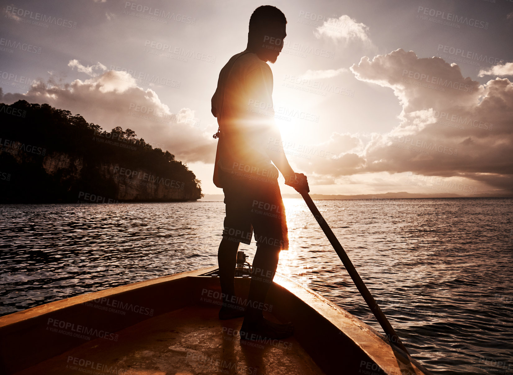 Buy stock photo Shot of a young man rowing a boat along the sea
