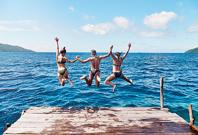 Buy stock photo Water, back of people jumping off a pier holding hands and into the ocean together in blue sky. Summer vacation or holiday break, freedom or travel and young group of friends diving into the lake