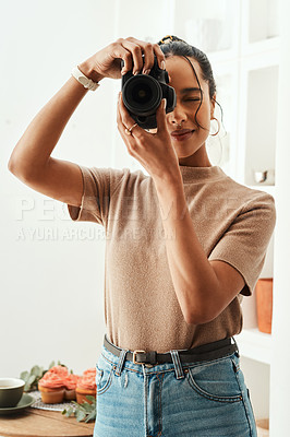 Buy stock photo Cropped shot of an attractive young businesswoman standing alone in her home and taking a picture with her camera