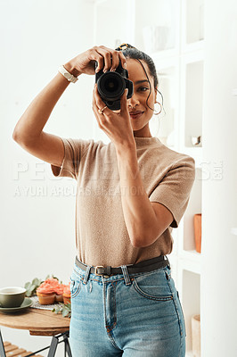 Buy stock photo Cropped portrait of an attractive young businesswoman standing alone in her home and taking a picture with her camera