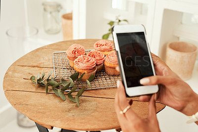 Buy stock photo Cropped shot of an unrecognizable businesswoman using her cellphone to take pictures of cupcakes for her blog