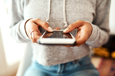 Buy stock photo Cropped shot of an unrecognizable businesswoman sitting indoors alone and texting on her cellphone