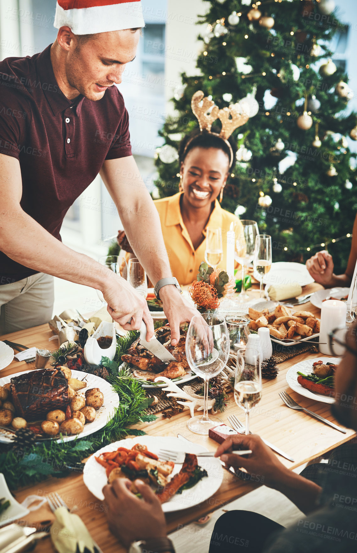 Buy stock photo Christmas, people and friends eating food at dining table for holiday celebration, bonding and social gathering. Dinner party, group and happy in home with roast lunch and cutting chicken in house