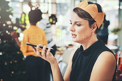 Buy stock photo Cropped shot of an attractive young woman taking a phonecall on Christmas day with her friends in the background