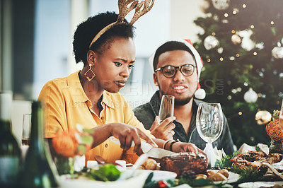 Buy stock photo Cropped shot of an attractive young woman cutting some turkey while dining with her husband on Christmas day at home