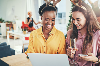 Buy stock photo Cropped shot of two attractive young girlfriends smiling while using a laptop together on Christmas day at home