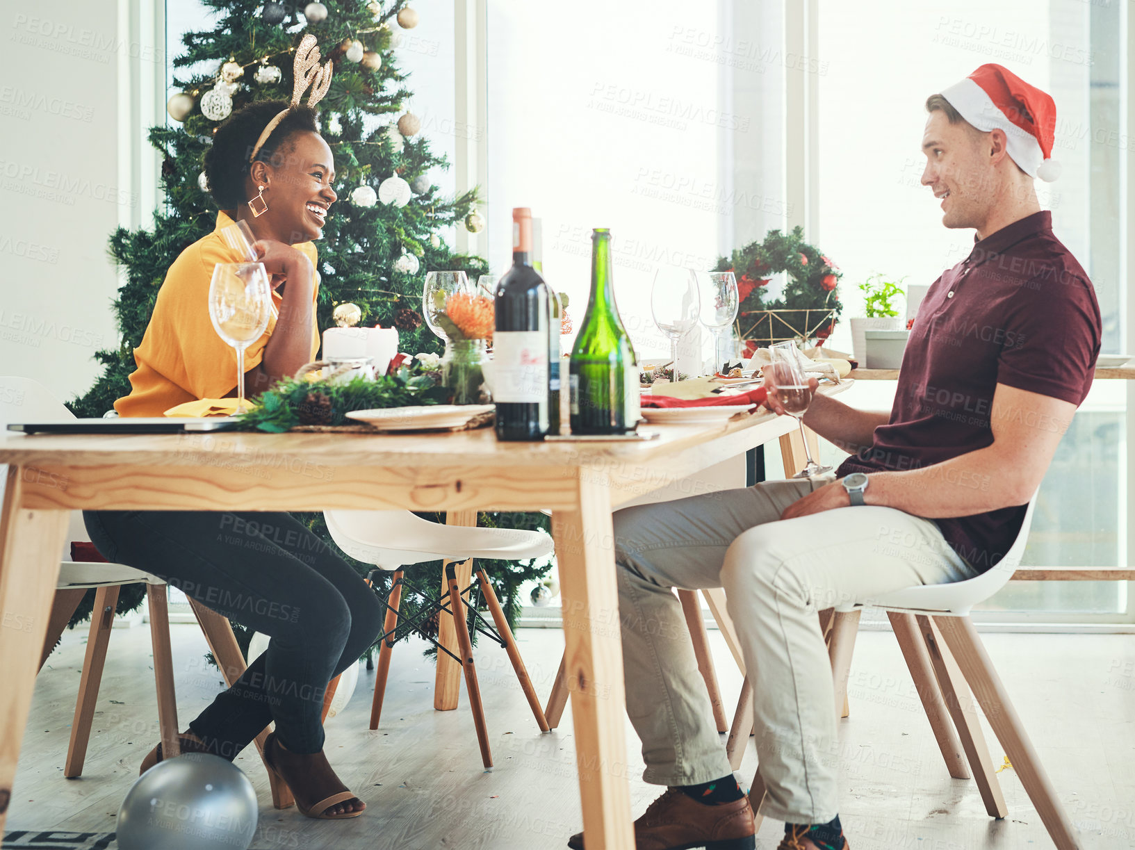 Buy stock photo Full length shot of a cheerful young couple having a chat during Christmas lunch at home