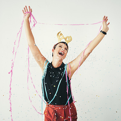 Buy stock photo Shot of an attractive and cheerful young woman celebrating with confetti falling around her against a grey background