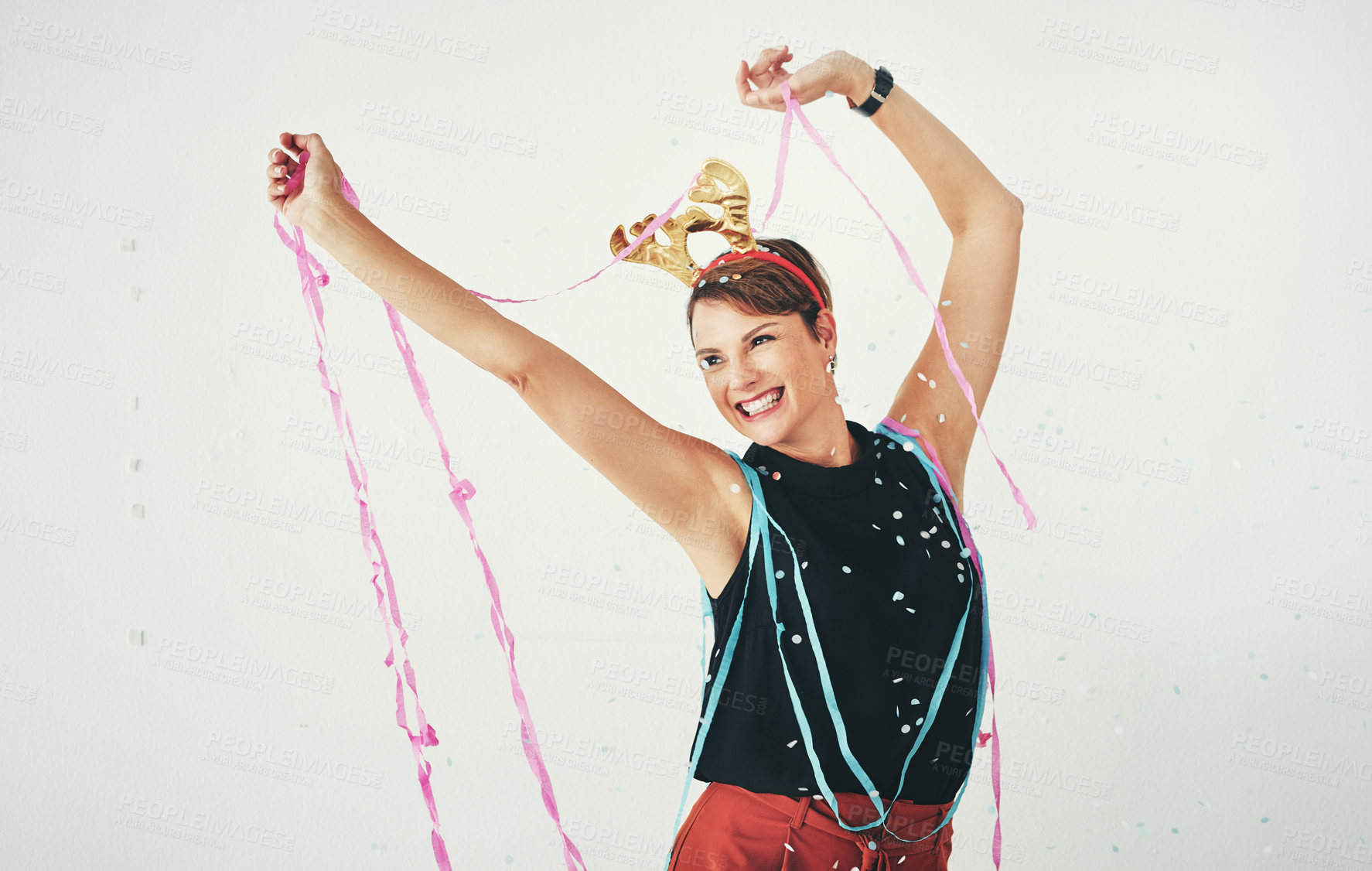 Buy stock photo Shot of an attractive and cheerful young woman celebrating with confetti falling around her against a grey background