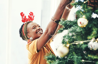 Buy stock photo Shot of an attractive young businesswoman decorating a Christmas tree in her office at work