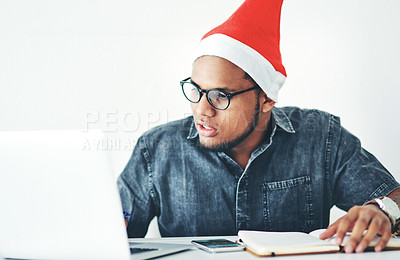 Buy stock photo Cropped shot of a handsome young businessman working in his office on Christmas Eve