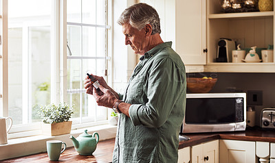 Buy stock photo CBD oil, tea and a senior man in the kitchen of a retirement home for his morning medication routine. Thinking, medical cannabis and dose with a mature man holding a medicine bottle in his house