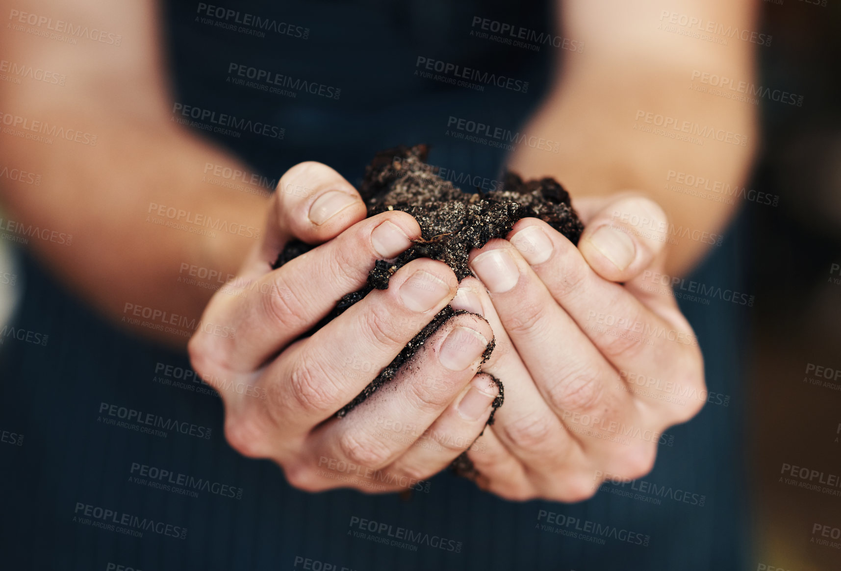 Buy stock photo Cropped shot of an unrecognizable florist holding potting soil inside her plant nursery