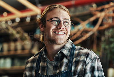 Buy stock photo Cropped shot of a handsome and happy young florist working inside his plant nursery