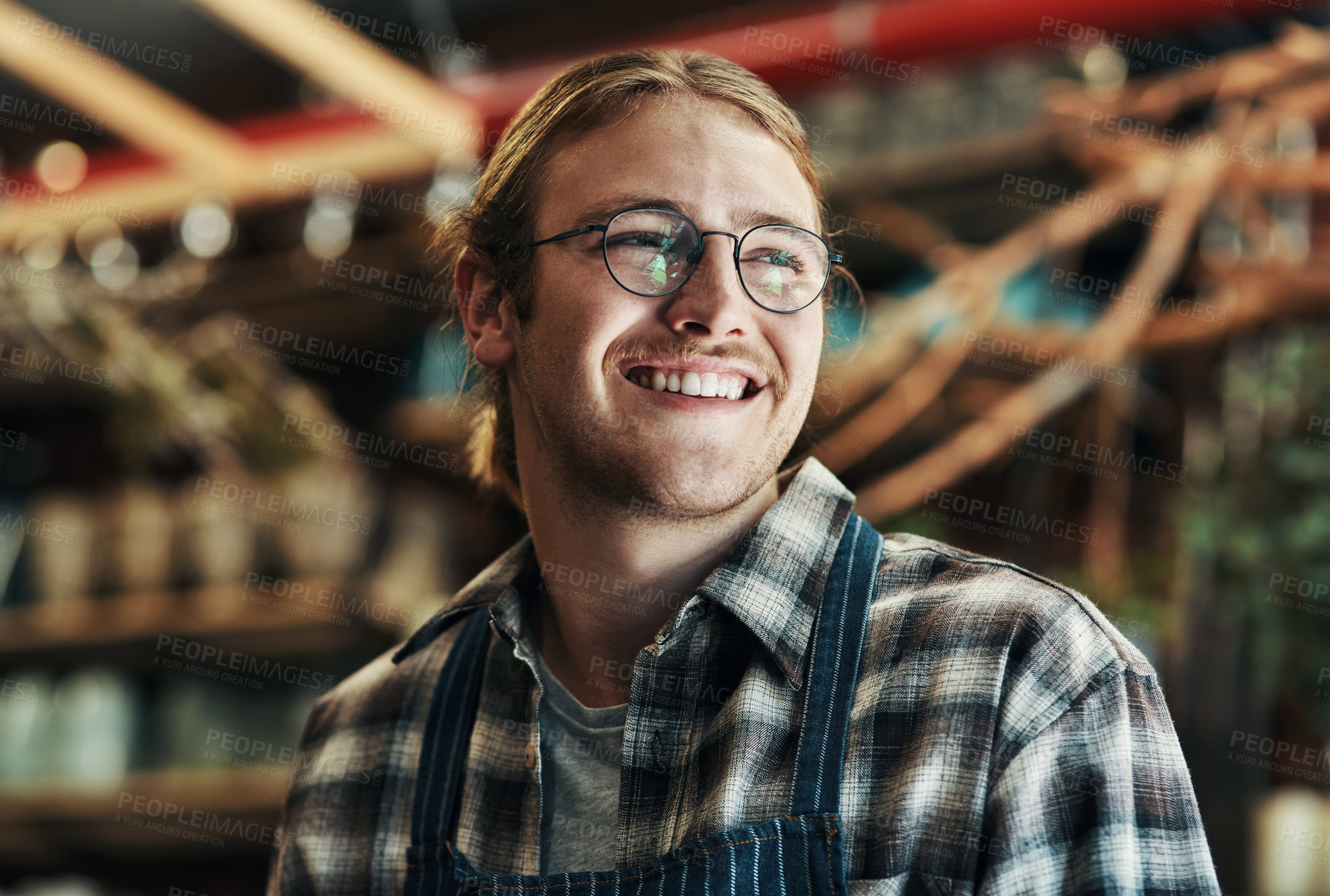 Buy stock photo Cropped shot of a handsome and happy young florist working inside his plant nursery