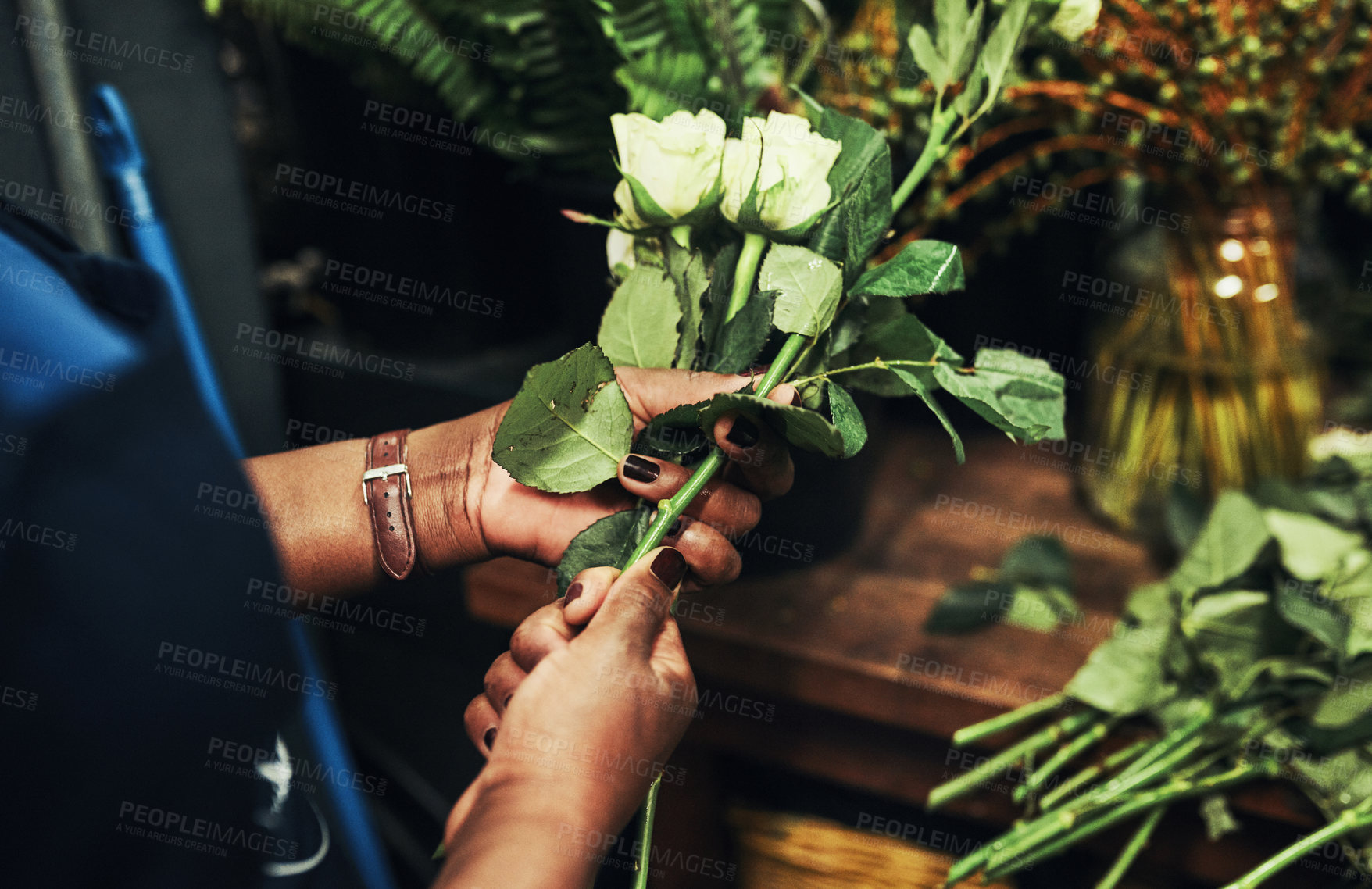 Buy stock photo Cropped shot of an unrecognizable florist arranging flowers inside her plant nursery