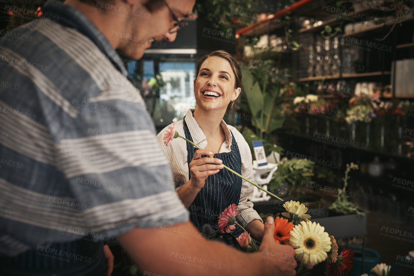 Buy stock photo Cropped shot of two young florists working together inside their plant nursery