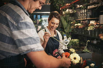 Buy stock photo Cropped shot of two young florists working together inside their plant nursery